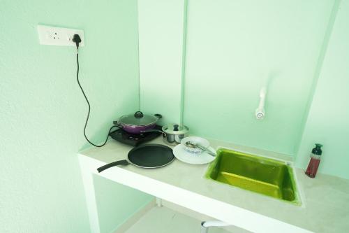 a kitchen counter with a sink and a mirror at Green Resort Pondicherry in Pondicherry
