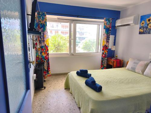 a bedroom with two beds and a window at Studio By the Beach in Saronida