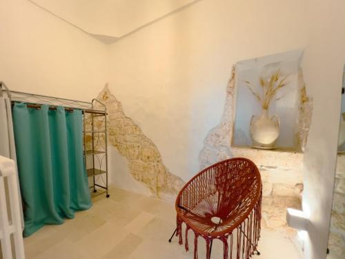 a room with green curtains and a rattan chair at Suite Ninfea romantic suite Ostuni center in Ostuni
