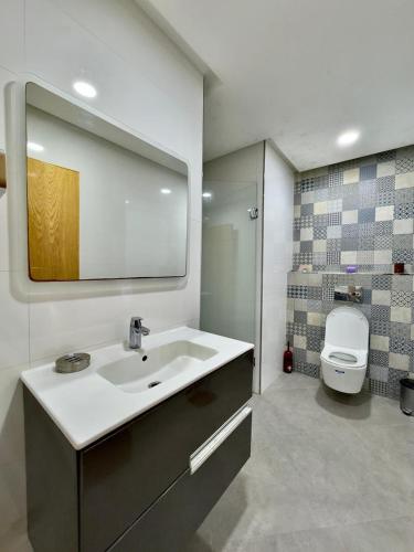 a bathroom with a sink and a toilet and a mirror at Riad Dar Salam in Agadir