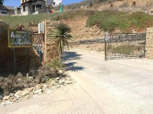 a gate with a sign and a palm tree on a hill at Casa concon mascotas estacionamiento in Valparaíso