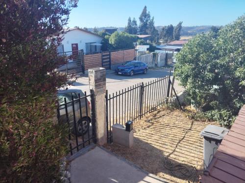 a fence with a car parked in a parking lot at Casa concon mascotas estacionamiento in Valparaíso