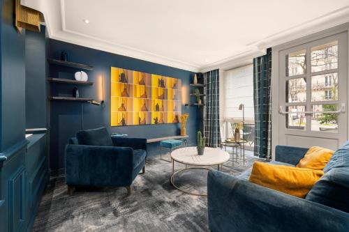 a living room with blue walls and blue furniture at Hôtel le Royal Rive Gauche in Paris