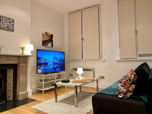 a living room with a tv and a fireplace at Spacious flat in Central London, only accept BANK wire to the host in London