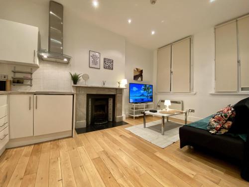 a living room with a couch and a tv and a fireplace at Spacious flat in Central London, only accept BANK wire to the host in London