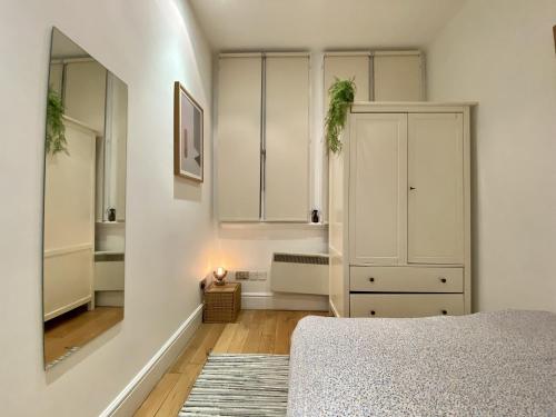 a bedroom with a bed and a white cabinet at Spacious flat in Central London, only accept BANK wire to the host in London