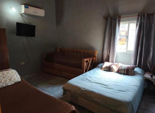a small bedroom with a bed and a window at Silvia Apart Confort in Puerto Iguazú