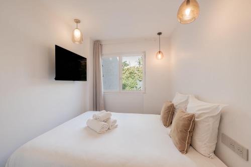a white bedroom with a bed with two stuffed animals on it at 6P apartment in a Citadelle with POOL - Saint-Tropez in Saint-Tropez