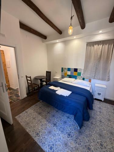 a bedroom with a large blue bed and a table at Anema e Core Salerno rooms in Salerno