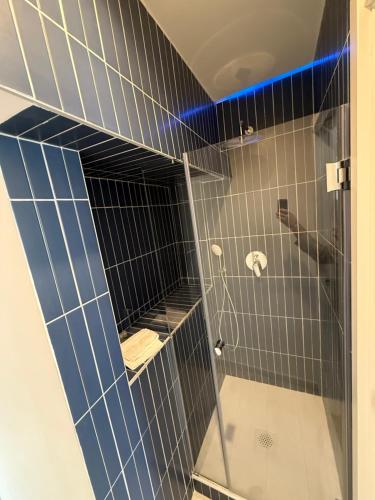 a bathroom with a shower with blue tiles at Anema e Core Salerno rooms in Salerno