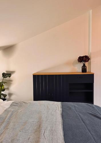 a bedroom with a bed and a desk with a vase of flowers at Silarozes in Mālpils