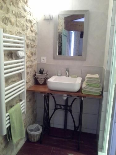 a bathroom with a sink and a mirror at Le Logis Du Four in Soudan