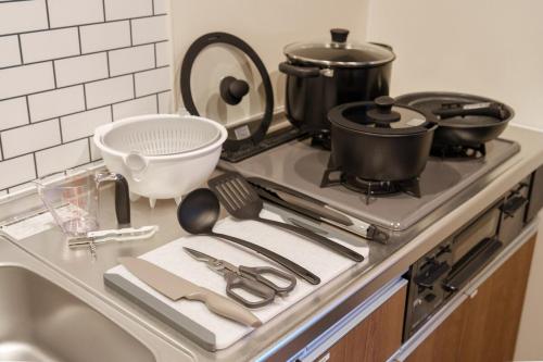 a kitchen counter with pots and pans on a stove at ZABOCON Honcho Terrace in Sapporo