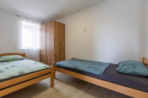 a bedroom with two beds and a cabinet at Apartments Sidro in Savudrija