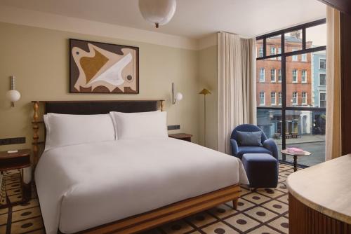a hotel room with a bed and a chair and a window at The Newman in London
