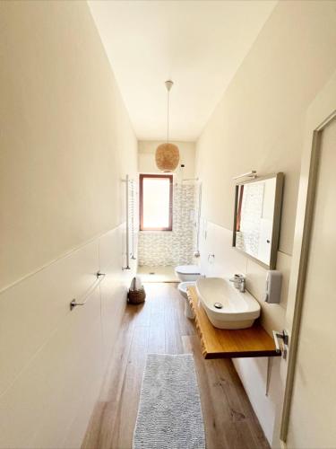 a white bathroom with two sinks and a mirror at TERRA DI SUD Matera - Free secure parking in Matera