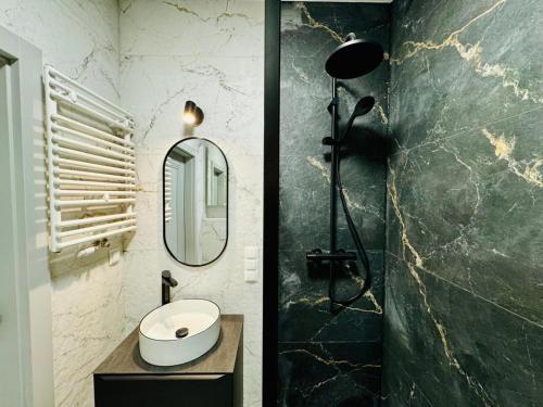 a bathroom with a sink and a mirror at Amber Seaside Apartment - Luxury Apartment with Balcony and Parking in Gdansk in Gdańsk