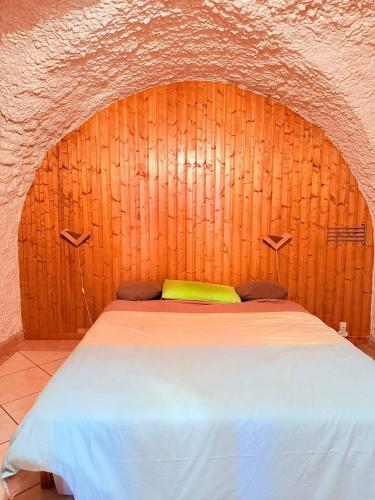 ein Bett in einem Zimmer mit einer Holzwand in der Unterkunft Maison Chamallow in Chorges