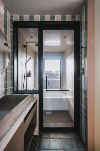 a bathroom with a tub and a sink and a window at THE TSUBAKIMORI Hotel & Residence in Chiba