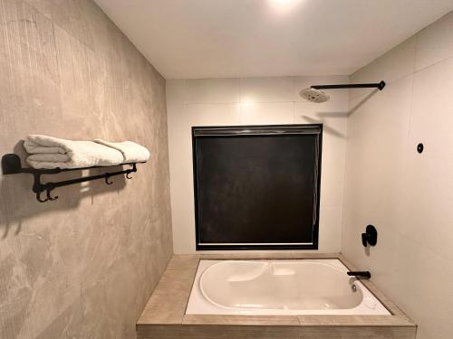 a bath tub in a bathroom with a black window at Taaffeite Hotels And Resorts in Lonavala
