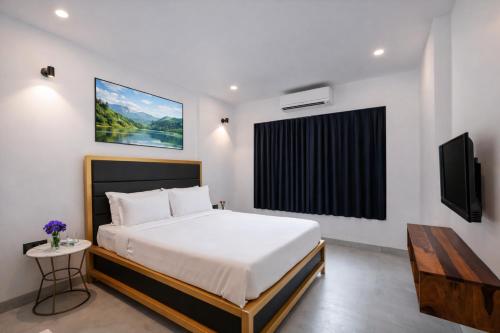 a bedroom with a bed and a flat screen tv at Taaffeite Hotels And Resorts in Lonavala