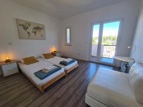 a bedroom with two beds and a couch and a window at Bright by the Beach - by CoH in Cruz Quebrada