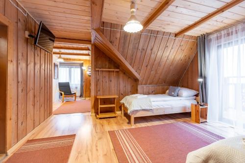 a bedroom with a bed in a room with wooden walls at U Stosela- wiejski dom w górach in Biały Dunajec