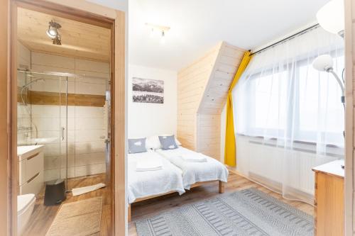 a bedroom with a bed and a shower and a bathroom at U Stosela- wiejski dom w górach in Biały Dunajec