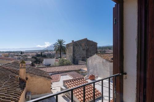 a cat sitting on a balcony looking out at the city at Casa Ombrina in Orosei