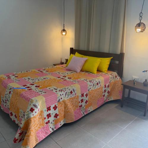 a bedroom with a bed with a quilt on it at Casa azul Recanto Doce Lar in Gravatá
