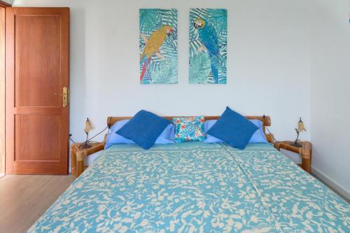 a bedroom with a bed with blue pillows at Villa Sila in El Paso
