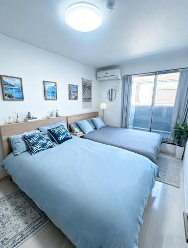 a bedroom with two beds and a window at Nan Hotel Osaka in Osaka