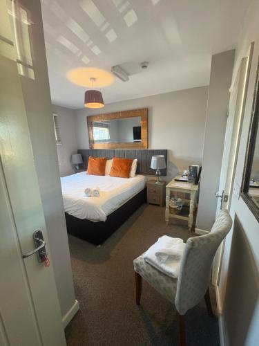 a bedroom with a bed and a chair in it at The Anchor Inn in Sutton Bridge