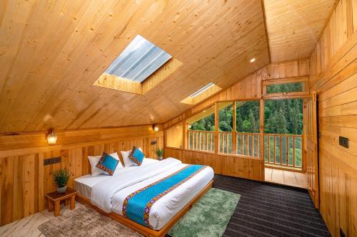 a bedroom with a bed in a wooden room with a skylight at Khwaab Stays in Shoja