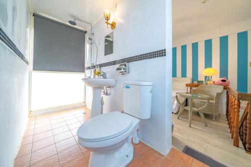 a bathroom with a toilet and a sink and a table at GREEN INN in Wujie