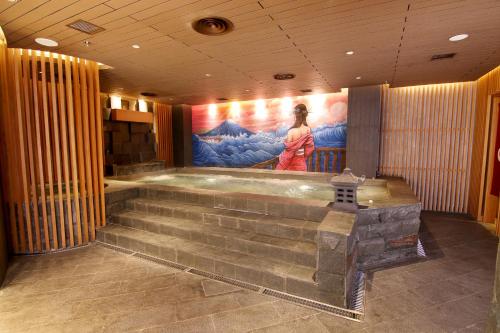 a bath tub in a room with a painting on the wall at Mercure Karawang in Karawang