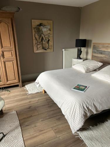 a bedroom with two beds and a table with a lamp at La Villa des Rosiers in Cricquebœuf