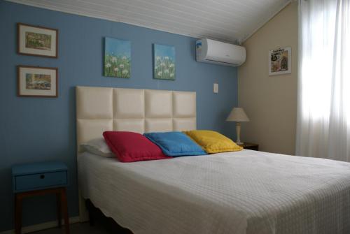 a bedroom with a bed with colorful pillows on it at recanto do paraiso in Penha
