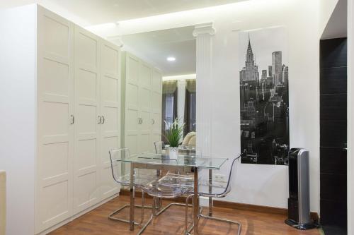 comedor con mesa de cristal y sillas en For You Rentals Plaza Dos de Mayo Apartment DP13, en Madrid