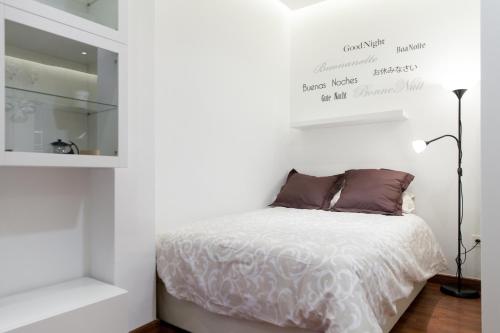 Habitación blanca con cama y espejo en For You Rentals Plaza Dos de Mayo Apartment DP13, en Madrid