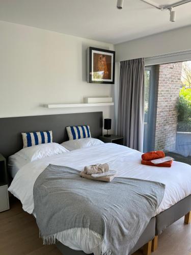 a bedroom with two beds and a large window at Business Accommodation 'Garden' Living Intimate in Geel