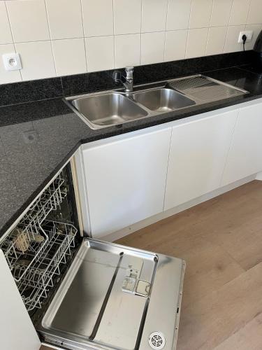 an empty kitchen with a sink and a dishwasher at Business Accommodation 'Garden' Living Intimate in Geel