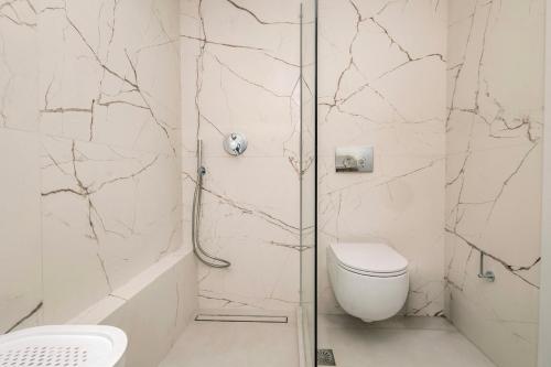 a white bathroom with a shower and a toilet at The Urban Core at Corfu Center! in Corfu