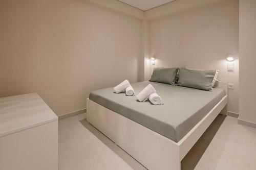 a white bedroom with a bed with two pillows on it at The Urban Core at Corfu Center! in Corfu