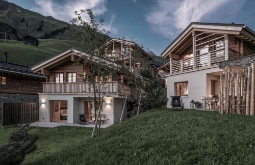 a house in the mountains with a yard at Aadla Walser-Chalets mit privater Sauna, Hotpot und Hotelservice in Schröcken
