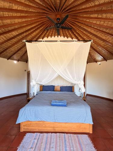 a bedroom with a bed with a large ceiling at Villa Ponjok Batu Residence in Bukti