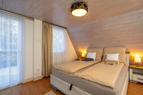 a bedroom with a bed with a wooden wall at Verőce-Szalamandra vendégház Hrsz 6905 in Kismaros