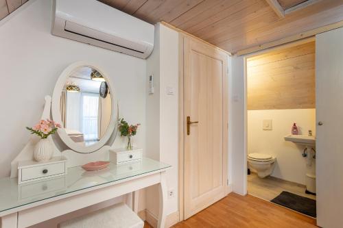 a bathroom with a mirror and a sink and a toilet at Verőce-Szalamandra vendégház Hrsz 6905 in Kismaros