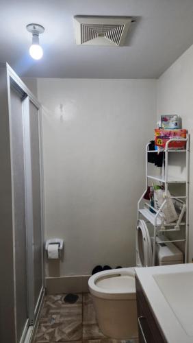 a white bathroom with a toilet and a sink at Condo Minsorado in General Trias