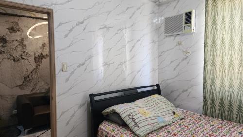a bedroom with a bed and a white wall at Condo Minsorado in General Trias